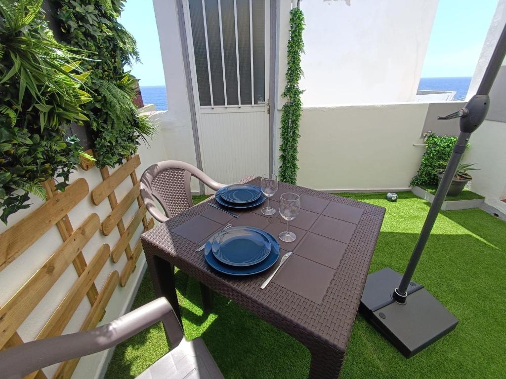 a table with blue plates on it on a patio at Studio avec terrasse et vue mer in El Escobonal