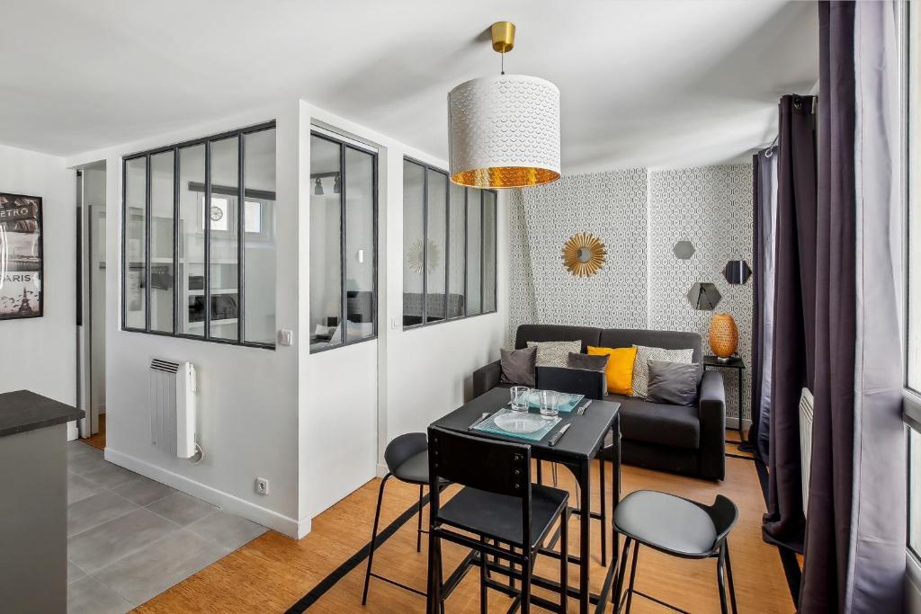 un salon avec une table, des chaises et un canapé dans l'établissement Studio au Cœur du Marais, Rue des Rosiers!, à Paris