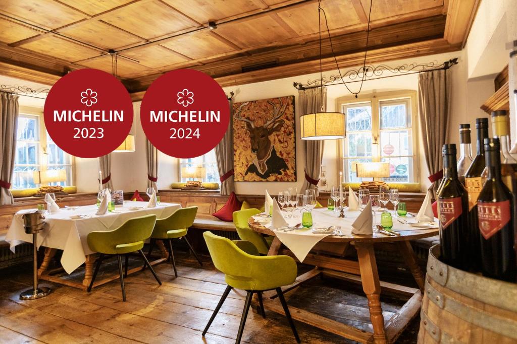 um restaurante com mesas, cadeiras e garrafas de vinho em Landgasthof Karner em Frasdorf