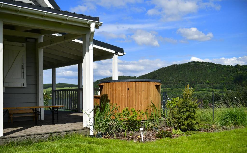 ein Haus mit einer Terrasse mit einem Holzfass in der Unterkunft Osada Aurora Całoroczne domki do wynajęcia nad jeziorem i w górach in Miszkowice
