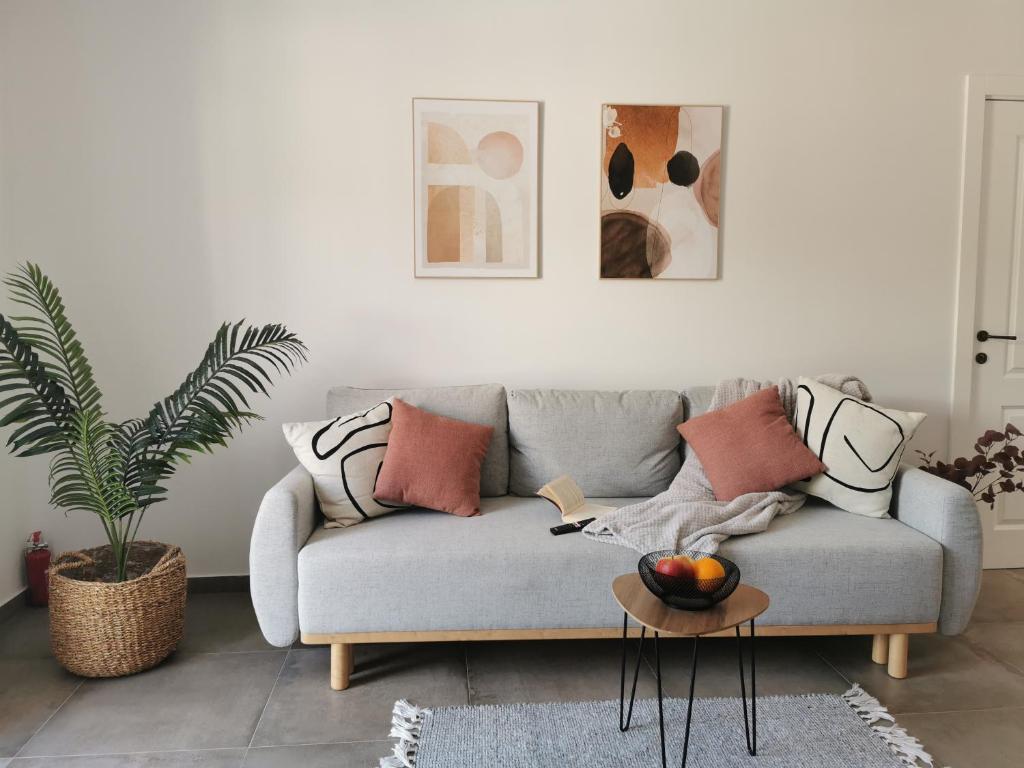 uma sala de estar com um sofá cinzento e uma mesa em Honoris Apartment - Brand new - Private parking - 90 m from the beach- Terrace em Slano
