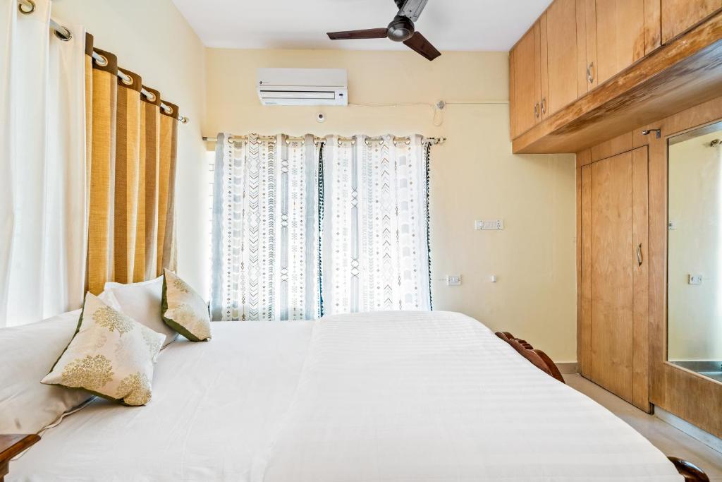 a bedroom with a white bed and a window at Ivory - Vintage Haven in Bangalore