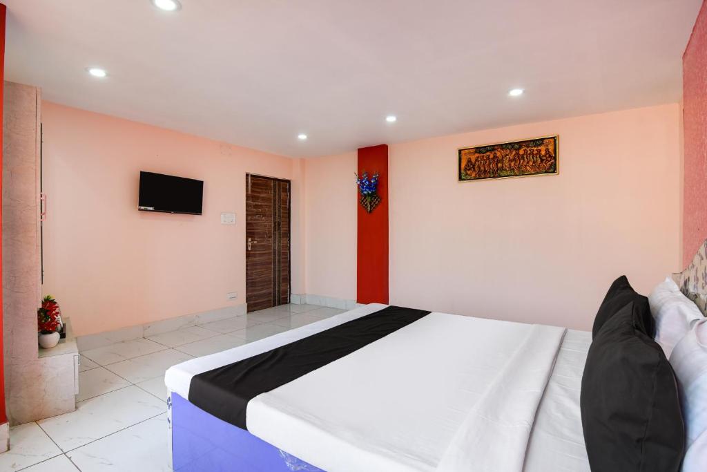加爾各答的住宿－OYO Royal Crown Banquet，卧室配有一张床,墙上配有电视。