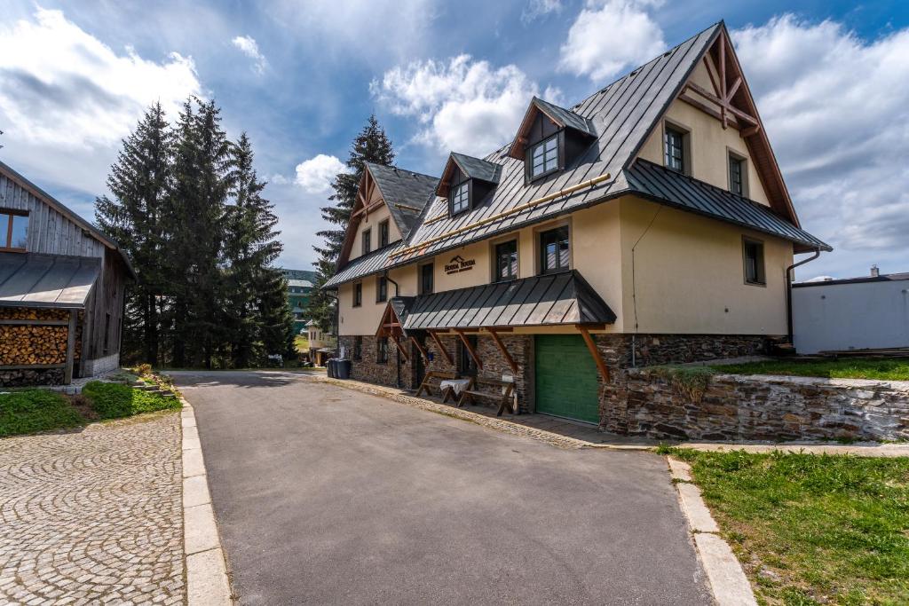 a large house with a road in front of it at Houda Bouda - Penzion & Apartmány in Boží Dar