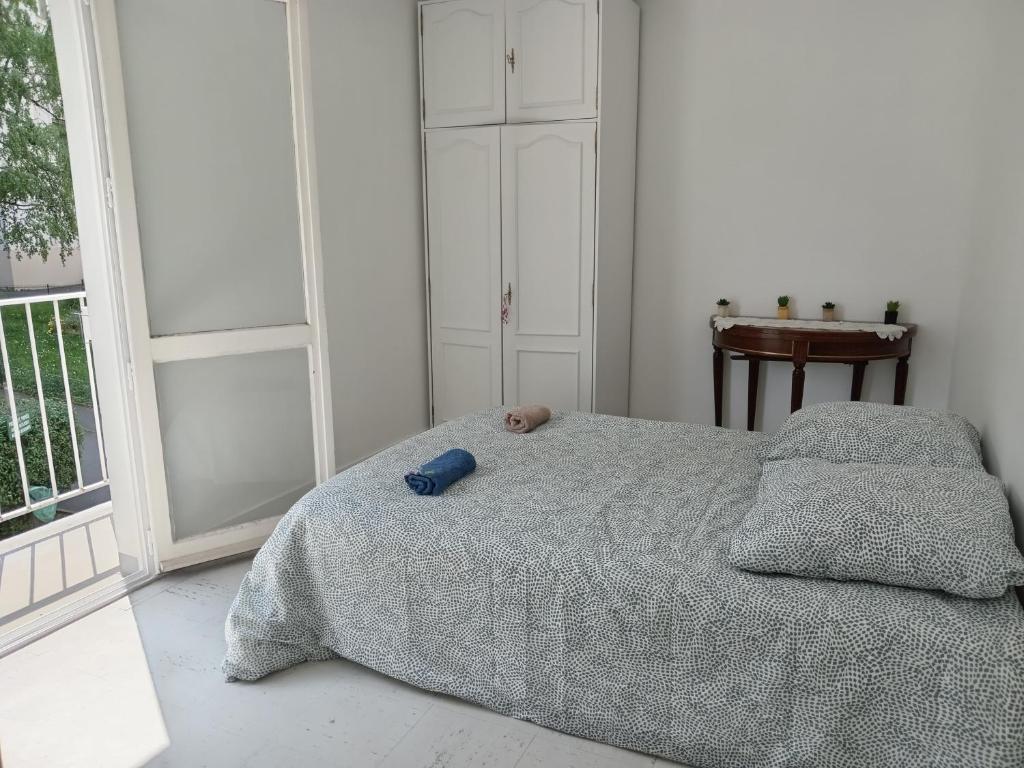 Un dormitorio con una cama con un osito de peluche encima. en chambre double lumineuse Paris centre deux pas du métro, en París