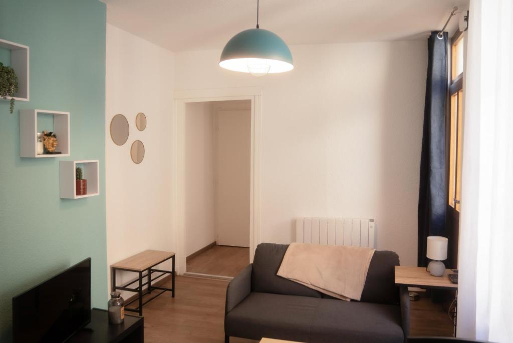 un salon avec un canapé et une télévision dans l'établissement L'évasion urbaine à la citadelle, à Chalon-sur-Saône