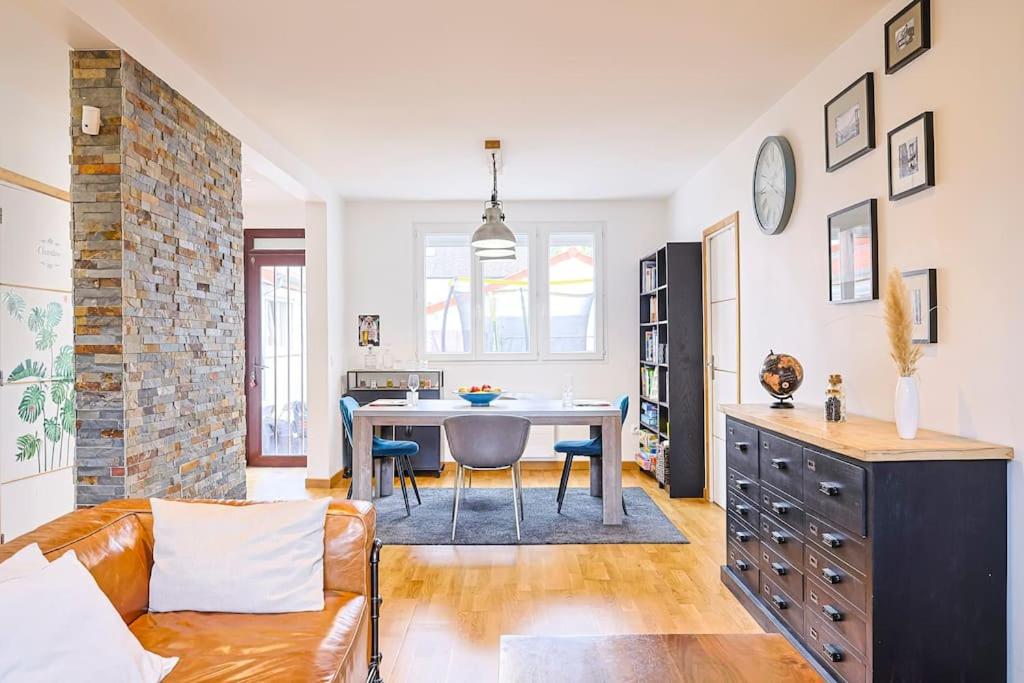 a living room with a couch and a table at Maison proche Disney in Chennevières-sur-Marne