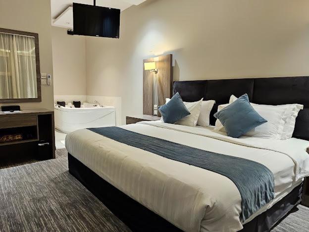 فندق ليان بارك Lian Park Hotel في الخبر: غرفة نوم بسرير كبير وحمام