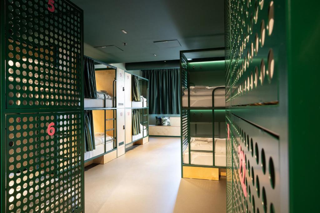 a hallway with bunk beds and a green wall at Bunks at Rode in Oslo