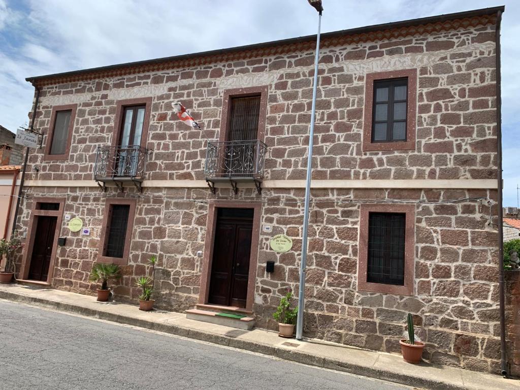 a brick building with windows and plants on it at Sa Domu in Fordongianus