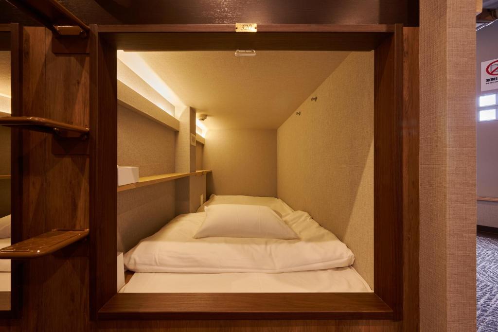 Postel nebo postele na pokoji v ubytování CAPSULE HOTEL CONTINUE NijojoKita