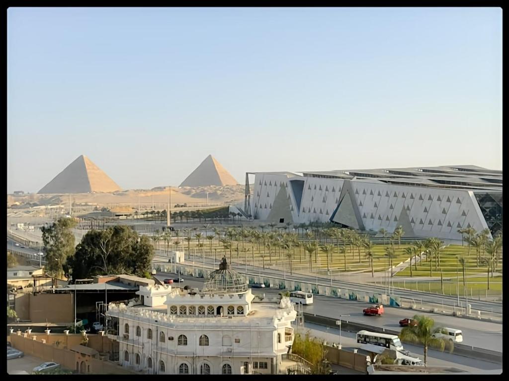 uma vista para um edifício com pirâmides ao fundo em Museum comfort view Giza ' pyramids em Giza