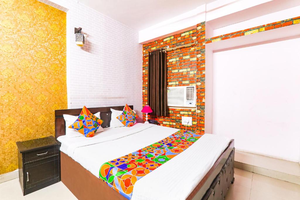 a bedroom with a large bed with colorful sheets at FabExpress The Hudco Grand in Patna