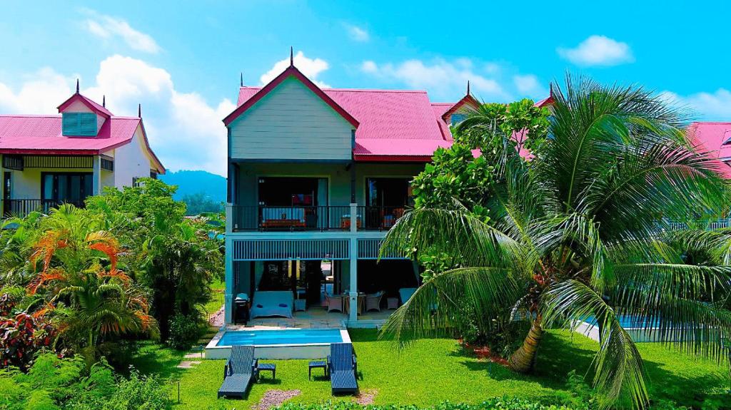 une maison avec un toit rose et une table de pique-nique devant elle dans l'établissement Eden Island Luxury Holiday Home, à Eden Island