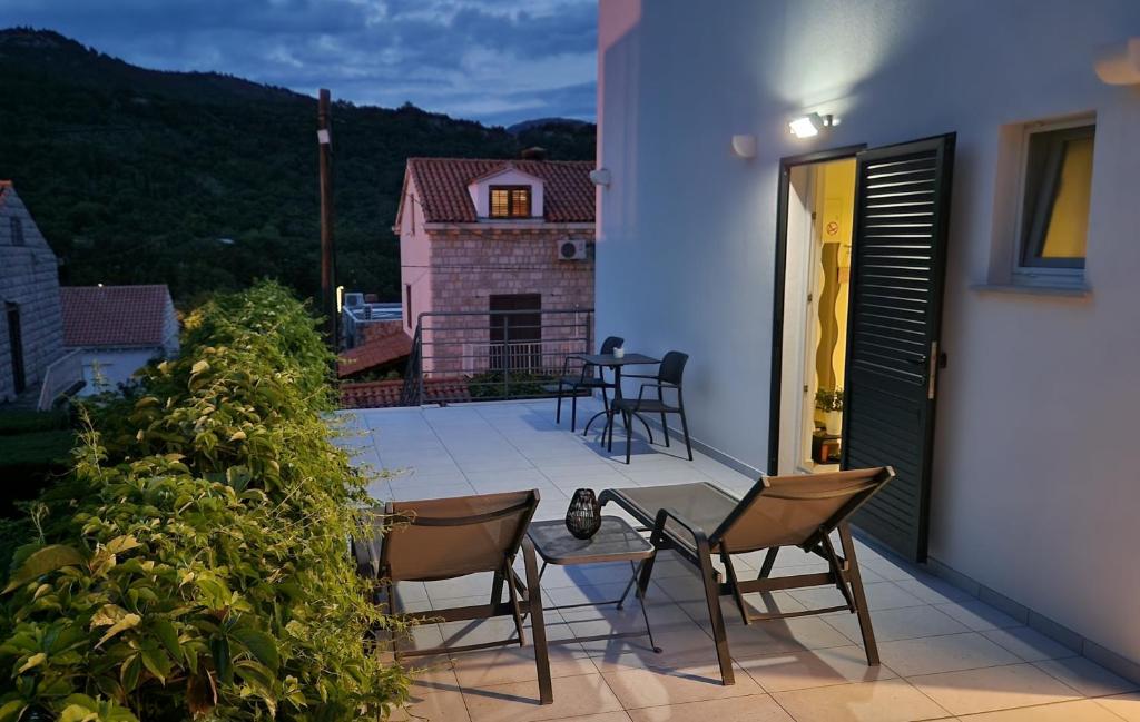 Un patio con sillas y una mesa en el balcón. en Vitis Apartments en Zaton