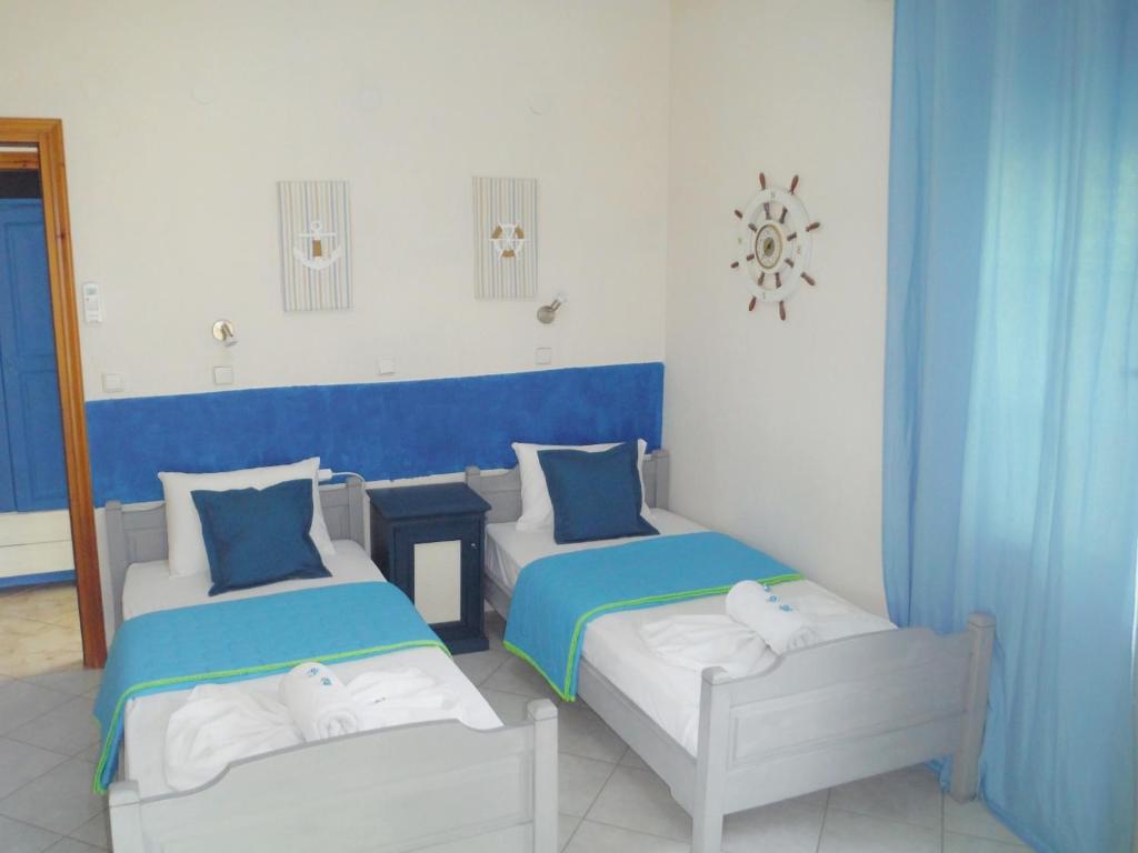 two beds in a room with blue and white at Port Rooms in Limenas