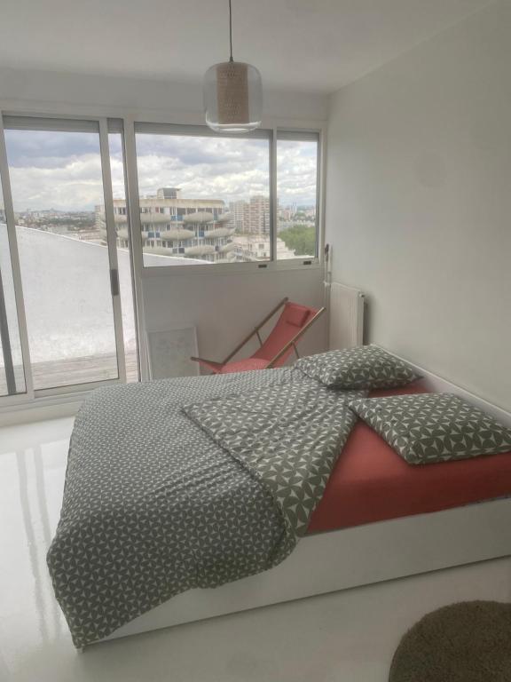 a bedroom with a bed and a view of the ocean at 14eme et dernier étage - 3 pieces "Arty" de 65 m2 avec vue panoramique ! in Créteil