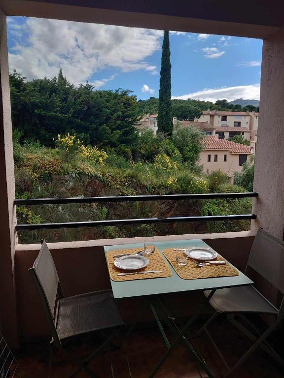 une table et des chaises sur un balcon avec vue dans l'établissement 4PA32 Appartement dans résidence avec piscine et parking, à Collioure