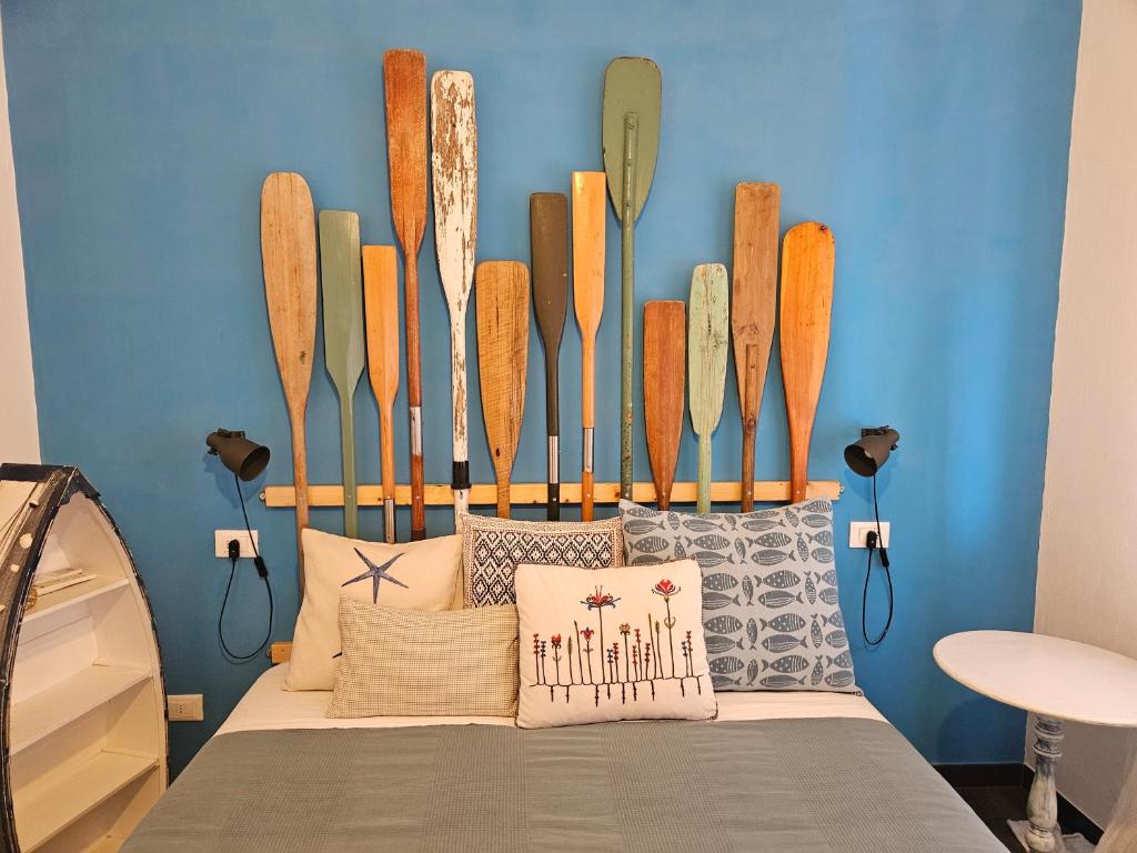 Zimmer mit einem Bett mit Surfbrettern an der Wand in der Unterkunft VILLA VILLACOLLE in Procchio