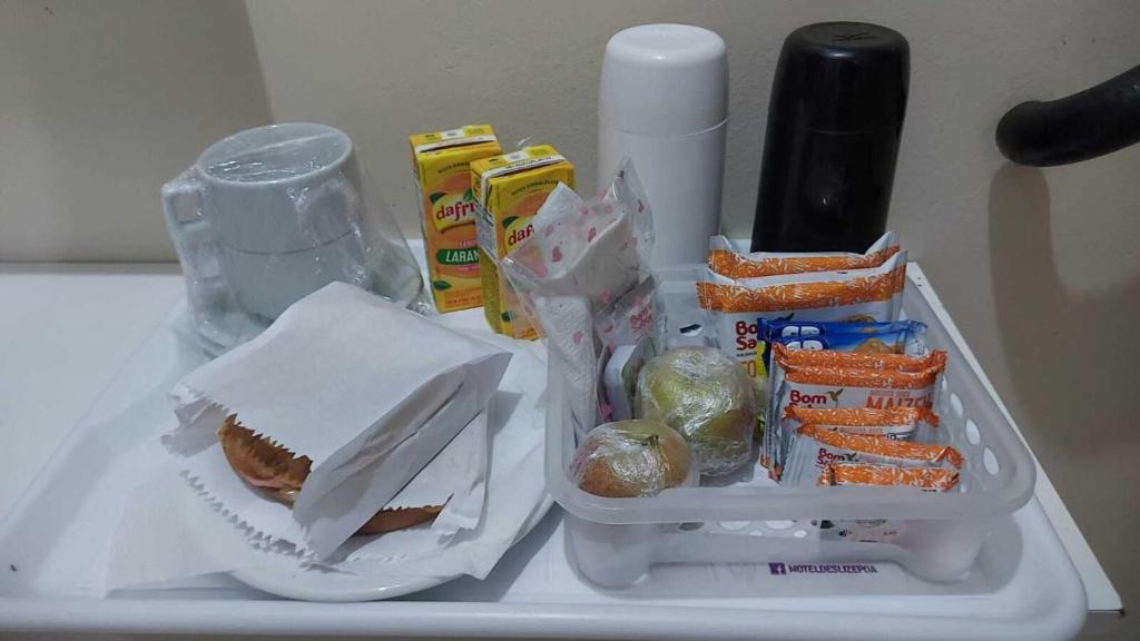 een koelkast met een broodje en ander voedsel erop bij Deslize Motel in Porto Alegre