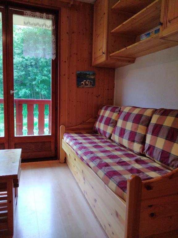 - un canapé dans une pièce avec fenêtre dans l'établissement Studio Cabine, plein centre de Valloire, à Valloire