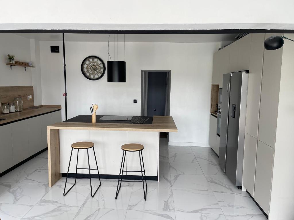 une cuisine avec un comptoir et deux tabourets dans l'établissement Appartement offrant une vue exceptionnel sur le jaizkibel et l'océan, à Hendaye