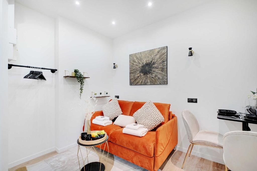 un salon avec un canapé orange et une table dans l'établissement Elegant Studio - 2P-Next to Place Pigalle, à Paris