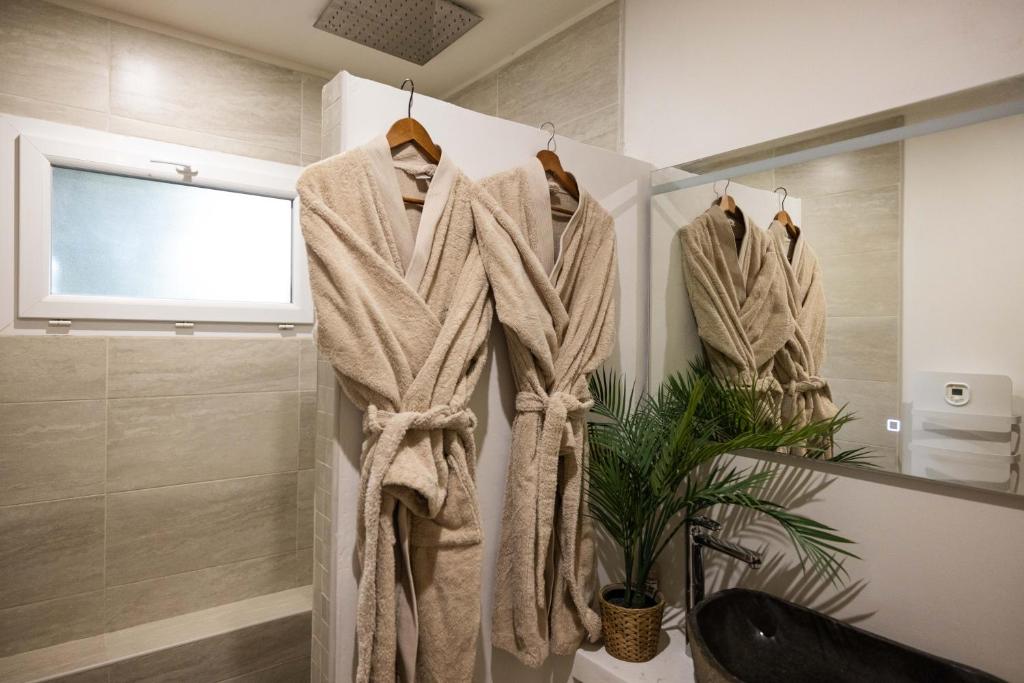 a bathroom with three towels hanging on a wall at Suite and Spa la Perla Bianca in Grabels