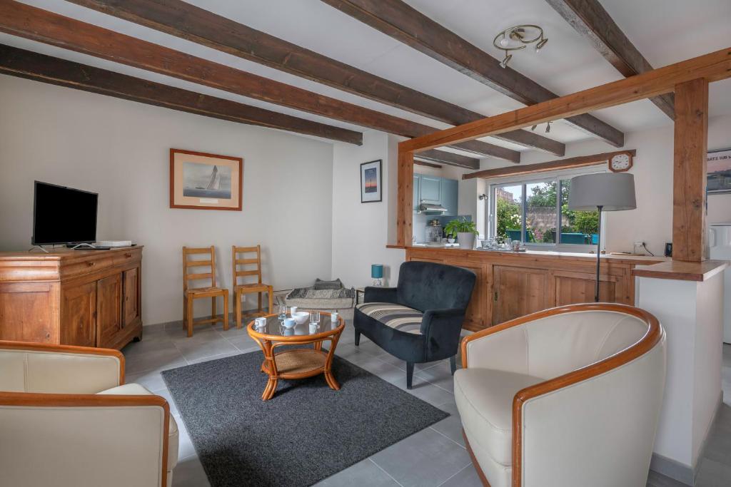 a living room with a table and chairs at À 400m des marais de Guérande - Maison de paludier in Kermoisan