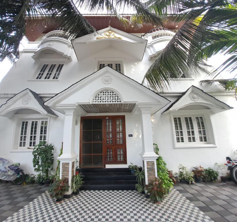Casa blanca con puerta roja en annies inn homestay en Kochi