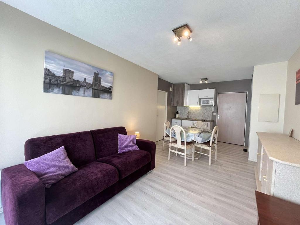 ラ・ロシェルにあるAppartement La Rochelle, 1 pièce, 2 personnes - FR-1-246-208の紫色のソファ付きのリビングルーム、キッチンが備わります。