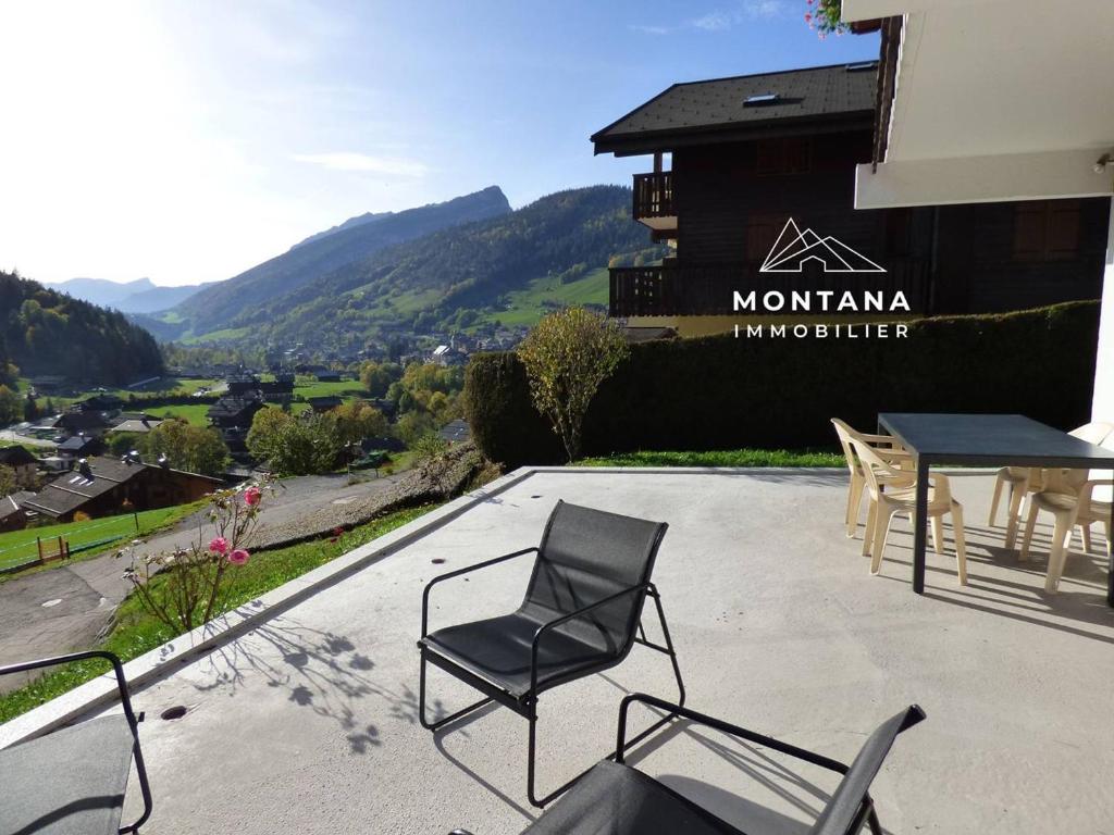 a patio with chairs and a table and a building at Appartement Le Grand-Bornand, 3 pièces, 5 personnes - FR-1-458-174 in Le Grand-Bornand