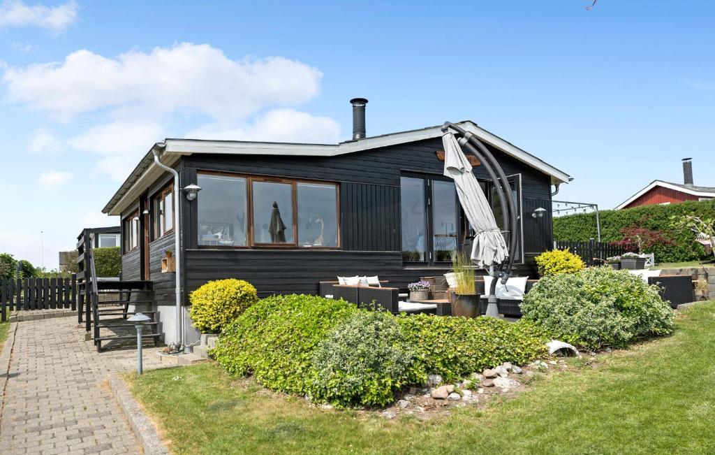 een zwart tiny house met een tuin bij 3 Bedroom Cozy Home In Juelsminde in Sønderby