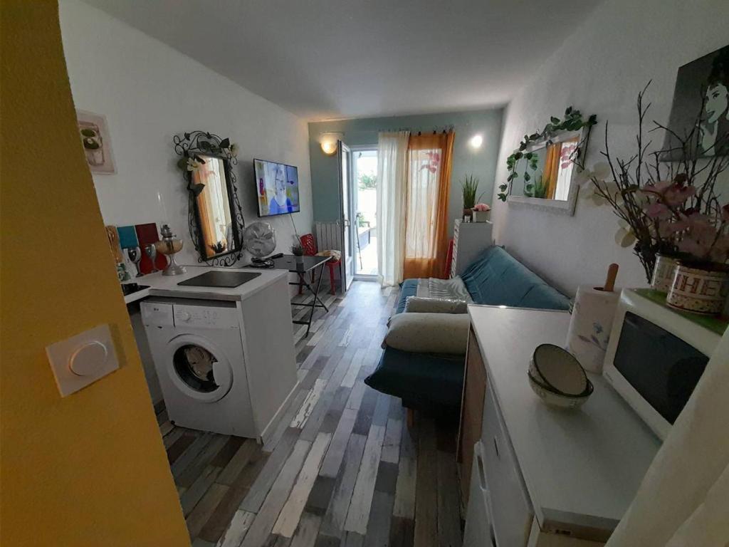 a kitchen and living room with a washing machine at Studio Saint-Hilaire-de-Riez, 1 pièce, 2 personnes - FR-1-324-564 in Saint-Hilaire-de-Riez