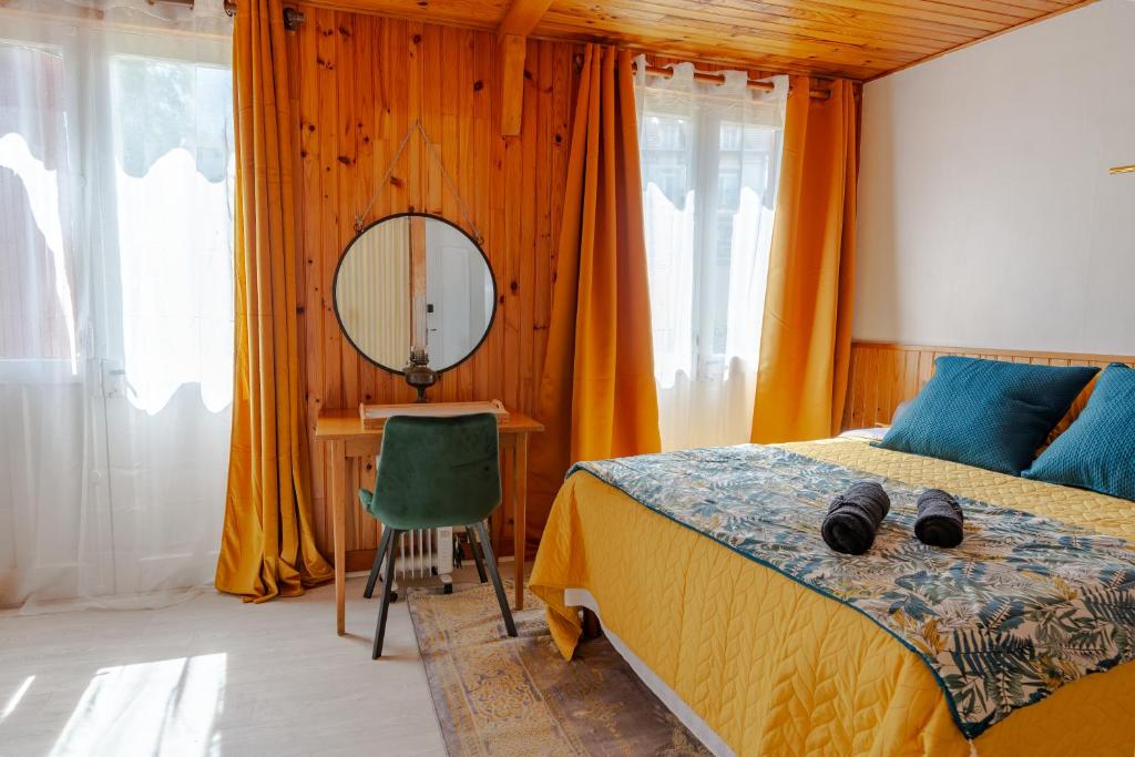 sypialnia z łóżkiem, biurkiem i lustrem w obiekcie La Rosée - Studio Campagne à 50m des Thermes - Vue jardin, Wifi, Netflix, Smart TV w mieście Bourbonne-les-Bains