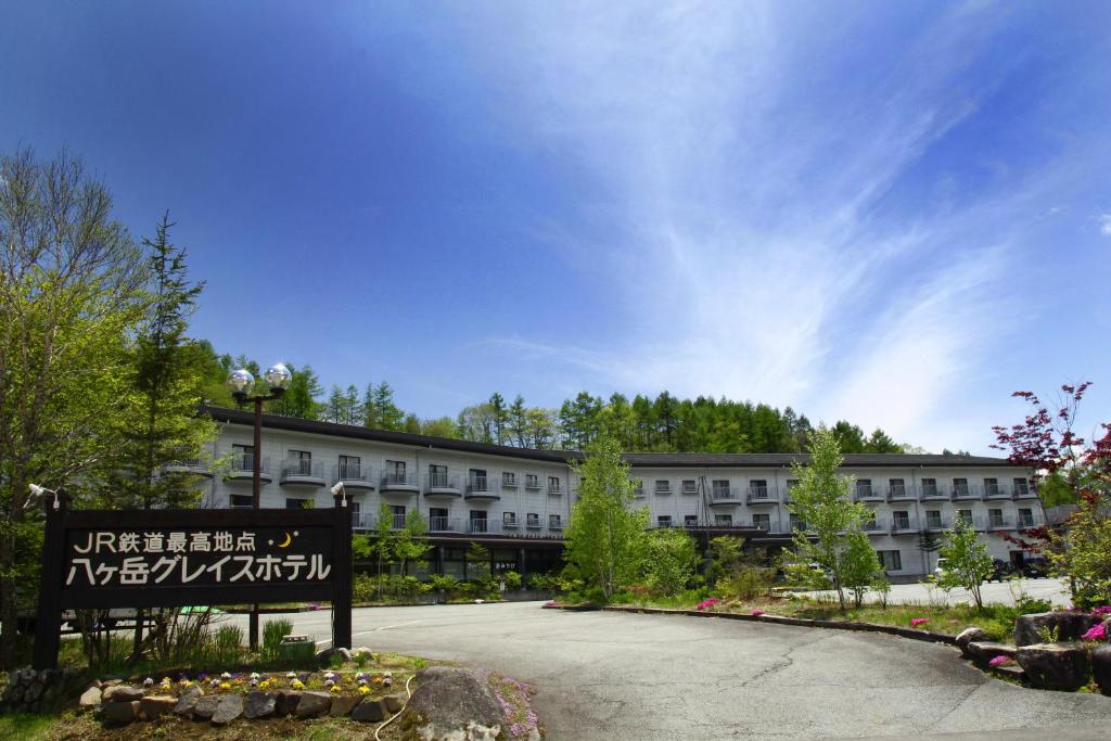 un grand bâtiment avec un panneau devant lui dans l'établissement Yatsugatake Grace Hotel, à Minamimaki