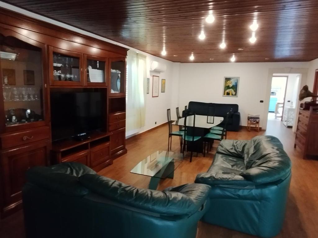 salon z 2 skórzanymi kanapami i stołem w obiekcie Casa di Lu’ w mieście Floridia