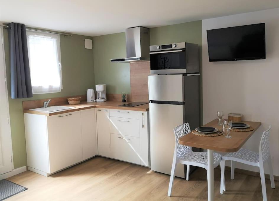 une petite cuisine avec une table et un réfrigérateur dans l'établissement T1 bis proche Marais avec garage à moto, à Bourges