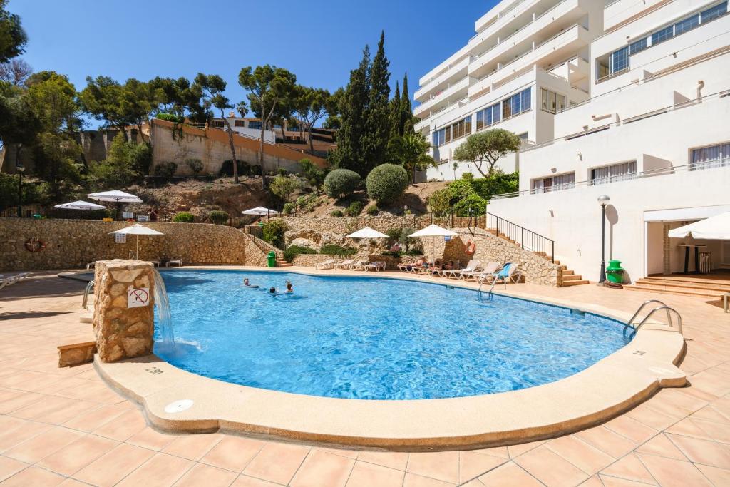 a swimming pool in a resort with people in it at Apartamentos Vista Club in Santa Ponsa