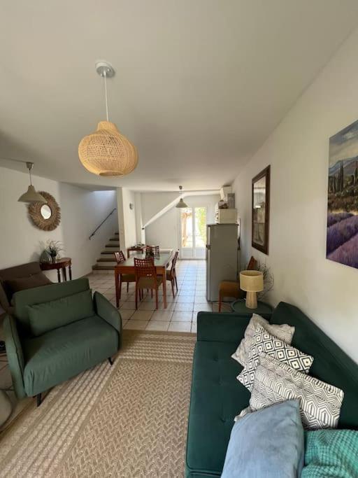 un salon avec un canapé vert et une salle à manger dans l'établissement Maison de Pêcheurs - cœur du Brusc 250 m de la mer, à Six-Fours-les-Plages