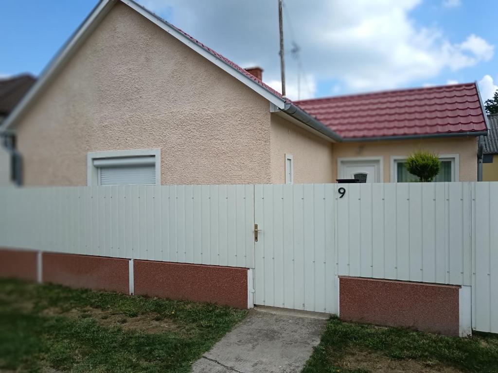 a white fence in front of a house at Margó Vendégházak 2 in Hajdúszoboszló