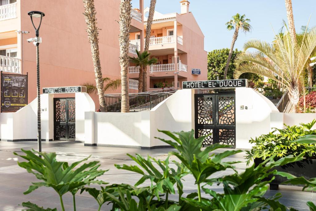a building with two doors and palm trees at Hotel El Duque in Adeje