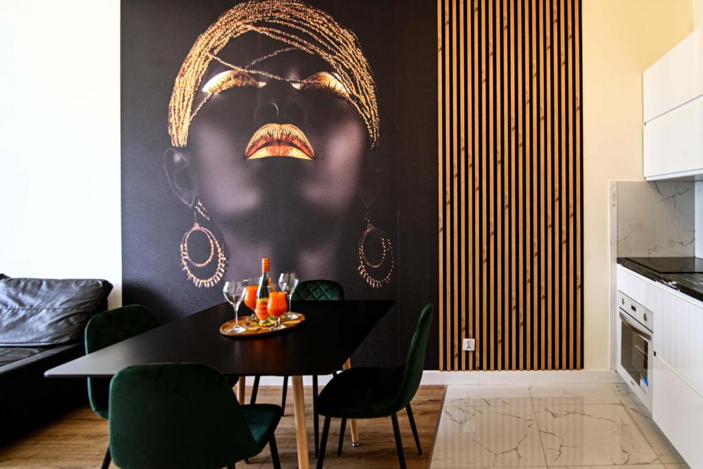 a dining room with a wall with a picture of a face at Apartament Królowej Nilu in Katowice