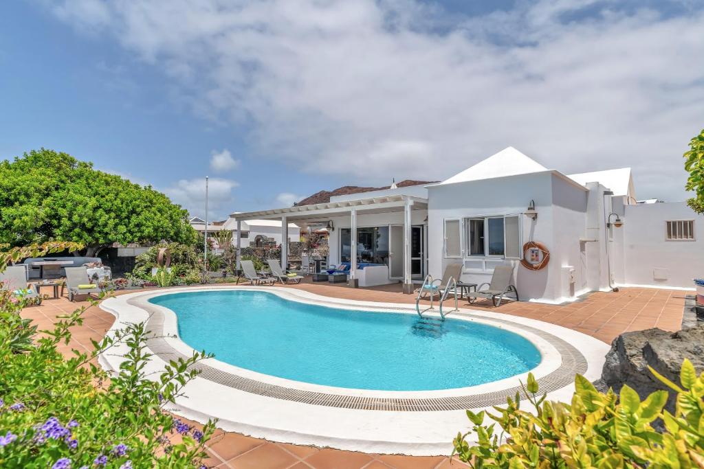 una villa con piscina frente a una casa en La Casita, en Playa Blanca