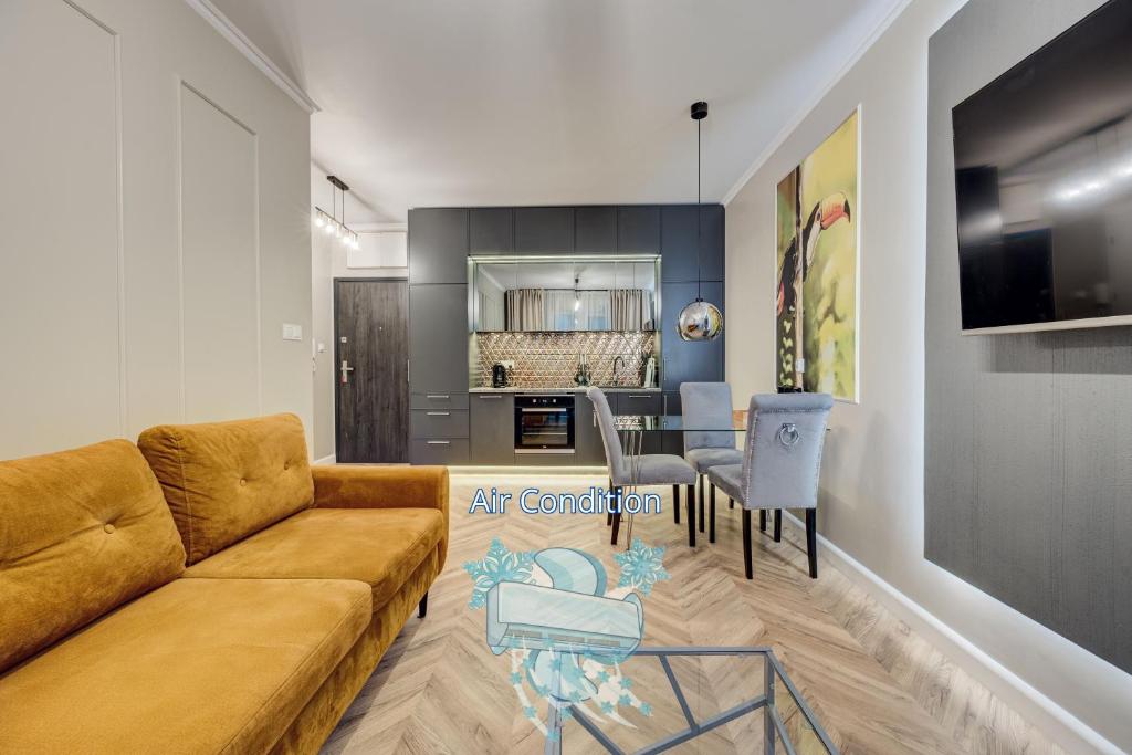 Allure NOVA Aparthotel في شتتين: غرفة معيشة مع أريكة ومطبخ