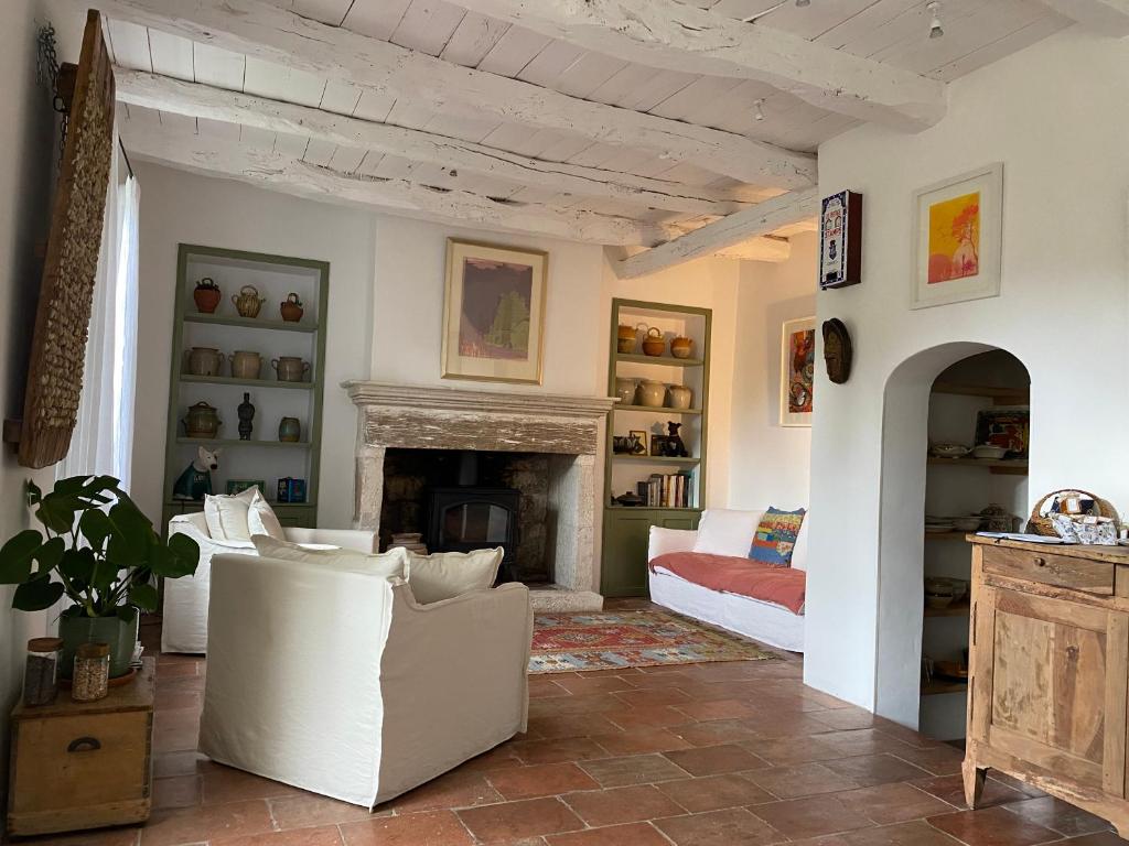a living room with white furniture and a fireplace at Le Coucou Montcuq in Montcuq