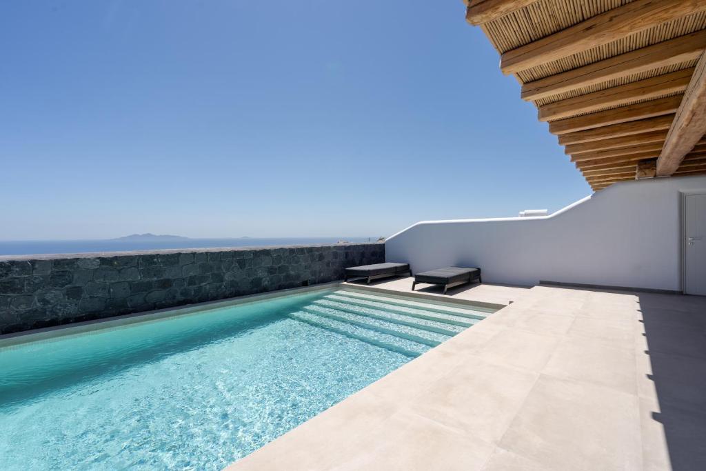 einen Infinity-Pool in einem Haus mit Aussicht in der Unterkunft NĒRO Suites by NOMÉE Hospitality Group in Imerovigli