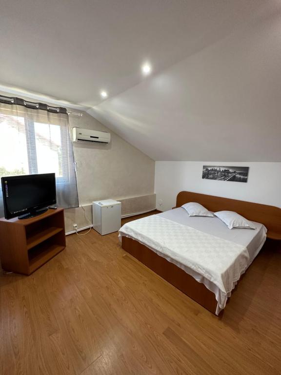 a bedroom with a bed and a flat screen tv at Casa Anda in Mangalia