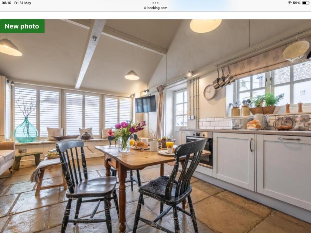 a kitchen with a wooden table and chairs at The Old Candle Shop in Little Walsingham