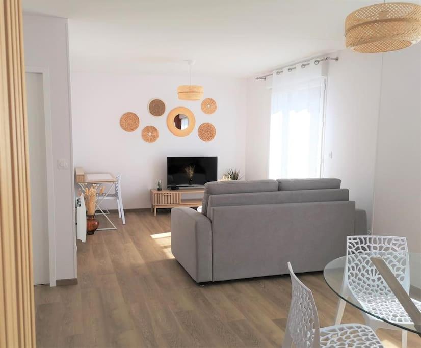 un salon avec un canapé et une cheminée dans l'établissement T2 proche Marais avec vue cathédrale et garage à moto, à Bourges